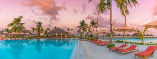 coucher de soleil de luxe sur la piscine à débordement dans un complexe hôtelier d'été en bord de mer dans un paysage tropical. ambiance de fond de vacances de vacances à la plage tranquille. vue imprenable sur la plage au coucher du soleil sur l'île, piscine de palmiers photo