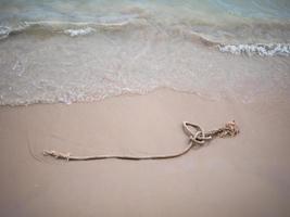 corde sur la plage de sable avec la vague de la mer photo