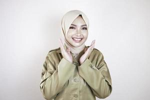 portrait d'une jeune femme musulmane asiatique portant un uniforme marron et un hijab souriant à la caméra. photo