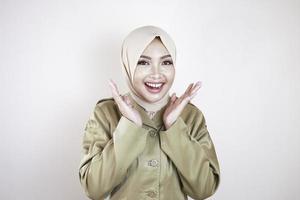 portrait d'une jeune femme musulmane asiatique portant un uniforme marron et un hijab souriant à la caméra. photo