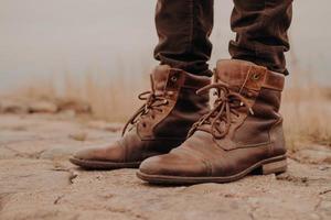 image des jambes de l'homme dans de vieilles bottes. concept de vente de chaussures. temps de l'automne. vue horizontale. prise de vue en extérieur. chaussure photo