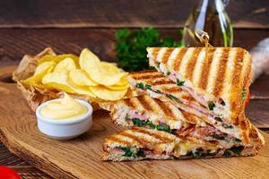 club sandwich avec jambon, fromage, tomate, salade et frites photo