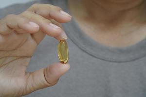 femme tenant avec une capsule d'huile de poisson oméga 3. photo