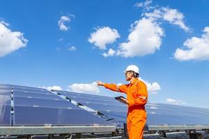 la ferme solaire, panneau solaire avec des ingénieurs à pied pour vérifier le fonctionnement du système, énergie alternative pour conserver l'énergie mondiale, idée de module photovoltaïque pour la production d'énergie propre photo