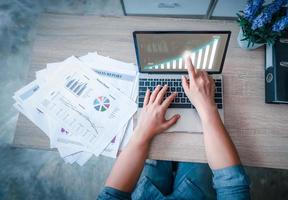 femme d'affaires touchant le moniteur d'ordinateur portable est sur la table de travail. idées d'objectifs commerciaux qui augmenteront de 2020 à 2021 et jusqu'à l'année prochaine photo