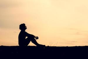 les silhouettes d'hommes sont assises dans le désespoir. le concept était découragé et sans espoir. photo