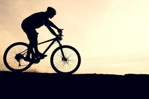 silhouettes de VTT et de cyclistes le soir joyeusement. concept de voyage et de remise en forme photo