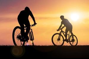 silhouettes de VTT et de cyclistes le soir joyeusement. concept de voyage et de remise en forme photo