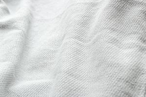 textile blanc froissé avec plié pour le fond. texture matérielle vue de dessus. concept minimaliste en gros plan. photo