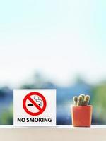 panneau non fumeur dans la chambre d'hôtel avec cactus sur table en bois. photo