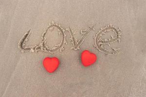 vue de dessus coeur rouge sur une plage de sable concept saint valentin photo