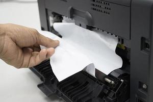 techniciens enlevant du papier coincé, bourrage de papier dans l'imprimante au bureau photo