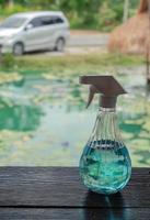 liquide bleu à 70 % d'alcool dans une bouteille de pompe brumeuse sur une table en bois au restaurant photo