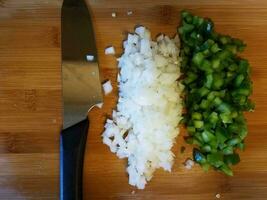 couteau et oignon et poivron vert sur une planche à découper photo