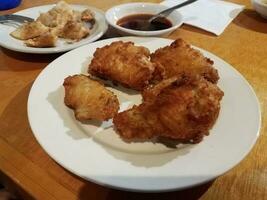 poulet coréen frit et boulettes et sauce soja sur assiette photo