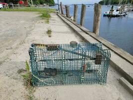 casier à homard ou cage sur la jetée avec eau et bateaux photo