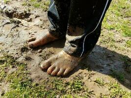 enfant avec des pieds boueux et de la boue et de l'herbe photo