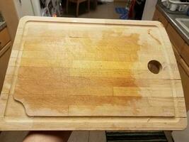 main tenant une planche à découper en bois humide dans la cuisine photo