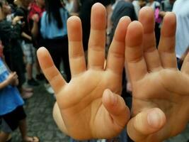 enfant dans la foule avec les mains devant le visage photo