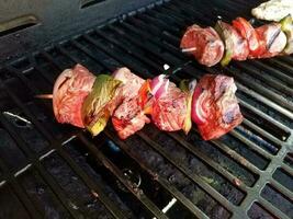 brochette de boeuf aux oignons et poivrons sur un bâton sur un grill avec du poulet photo