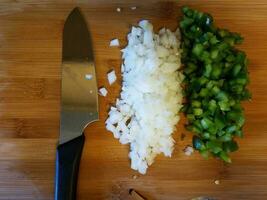 couteau et oignon et poivron vert sur une planche à découper photo