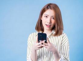 image de jeune fille asiatique utilisant un smartphone sur fond bleu photo