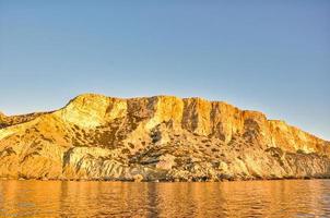 côte de la plage rouge de matala avec sable et mer bleue photo