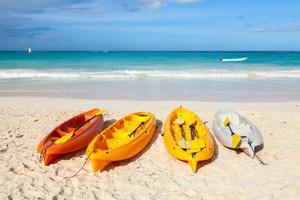 kayaks en plastique colorés se trouvent sur une plage de sable vide photo