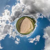 petite planète. vue sphérique dans un champ en belle journée avec de beaux nuages photo