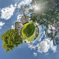 petite planète. vue aérienne sphérique en forêt près de la maison de vacances en belle journée avec de beaux nuages photo