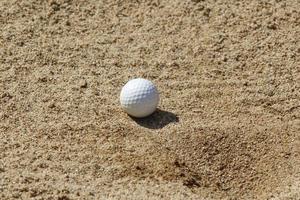 balle de golf dans un piège à sable photo