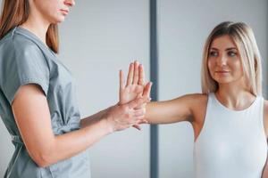 bouger la main. la femme est au centre de santé et reçoit l'aide d'un médecin photo