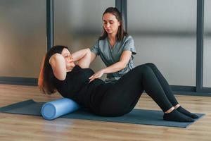 à l'aide d'un tapis de yoga. la femme est au centre de santé et reçoit l'aide d'un médecin photo