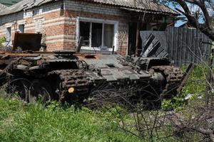 kharkiv, ukraine - 04 mai 2022. un char russe brûlé près d'un immeuble résidentiel. guerre en ukraine 2022. missiles russes dans la campagne de kharkiv en ukraine. attaque russe contre l'ukraine. photo