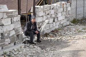 kharkiv, ukraine mai, 04, 2022. une femme âgée est assise et pleure à la porte de sa maison en ruine. missiles russes à kharkiv en ukraine. agression russe. attaque russe contre l'ukraine. photo