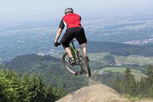 cavalier de vélo de montagne sautant précipice photo