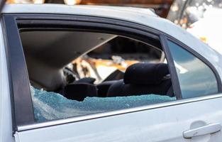 incident criminel. entrer par effraction dans une voiture garée dans la rue. verre latéral cassé et l'habitacle derrière. un crime commis par un voleur, voler des choses. voiture après un accident. photo