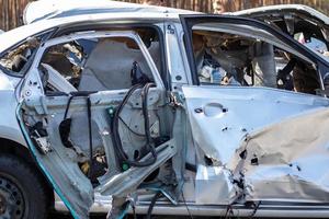 une voiture déformée, aplatie après un accident, après un fort choc latéral. accident de voiture, concept d'assurance. voiture terriblement dangereuse après un accident mortel. conduite dangereuse imprudente. danger automobile. photo