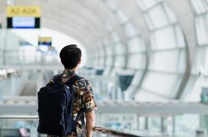 homme asiatique avec sac de transport debout et impatient d'attendre de voyager après la pandémie. photo