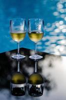 deux verres de vin blanc mis sur table à la piscine pour les vacances et le concept de boisson d'été. photo