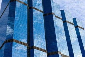 ciel bleu et nuages reflétés sur le verre des immeubles de bureaux dans le centre-ville par une belle journée ensoleillée. photo