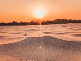 coucher de soleil dans le désert, désert au coucher du soleil en gros plan avec le sol, dunes de sable soleil au sommet de la forêt, dunes de sable au coucher du soleil du soir photo