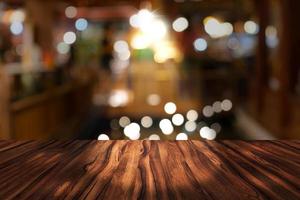 bureau supérieur avec fond de restaurant flou, table en bois et bokeh flou de fond de rue de nuit photo