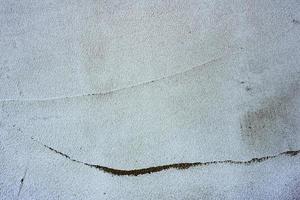 texture d'un mur de béton avec des fissures et des rayures qui peuvent être utilisées comme arrière-plan photo