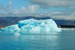 iceberg bleu clair brillant flottant dans l'eau froide bleue du lac jokulsarlon en islande 34 photo