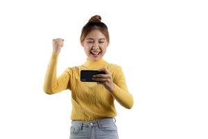 portrait d'une belle femme asiatique dans une chemise jaune jouant sur un smartphone. concept de portrait utilisé pour la publicité et la signalisation, isolé sur fond blanc, espace de copie. photo