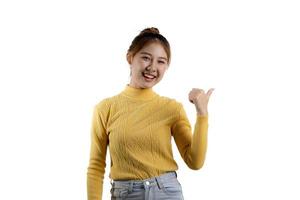 portrait d'une belle femme asiatique dans une chemise jaune debout et pointant. concept de portrait utilisé pour la publicité et la signalisation, isolé sur fond blanc, espace de copie. photo