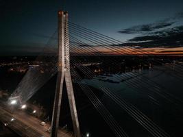 vue panoramique aérienne du pont de riga sur la rivière daugava la nuit. pont à haubans à riga, lettonie la nuit. photo