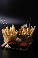 frites dans un panier sur fond noir photo