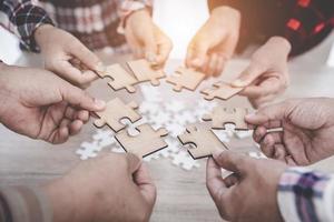 un groupe de gens d'affaires assemble des puzzles, des concepts de coopération, de travail d'équipe, d'aide et de soutien dans les affaires, symbole d'association et de connexion. stratégie d'entreprise. photo